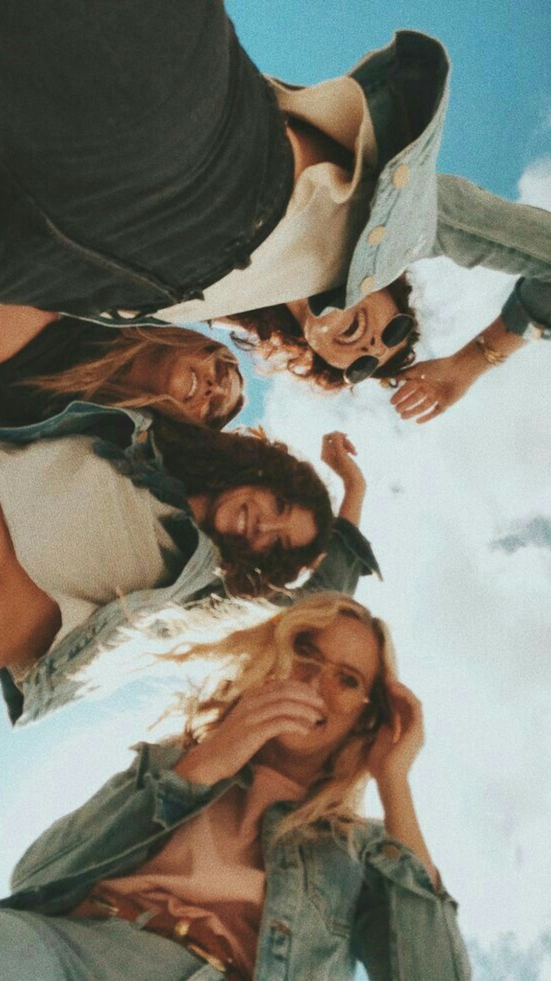 Quattro amiche viste dal basso contro il cielo